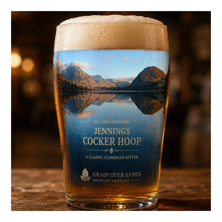 A pint glass of beer with a printed scenic label reading 'Jennings Cocker Hoop' and 'Grain Over Sands Brewing Supplies,' standing on a wooden table in a dimly lit pub setting.